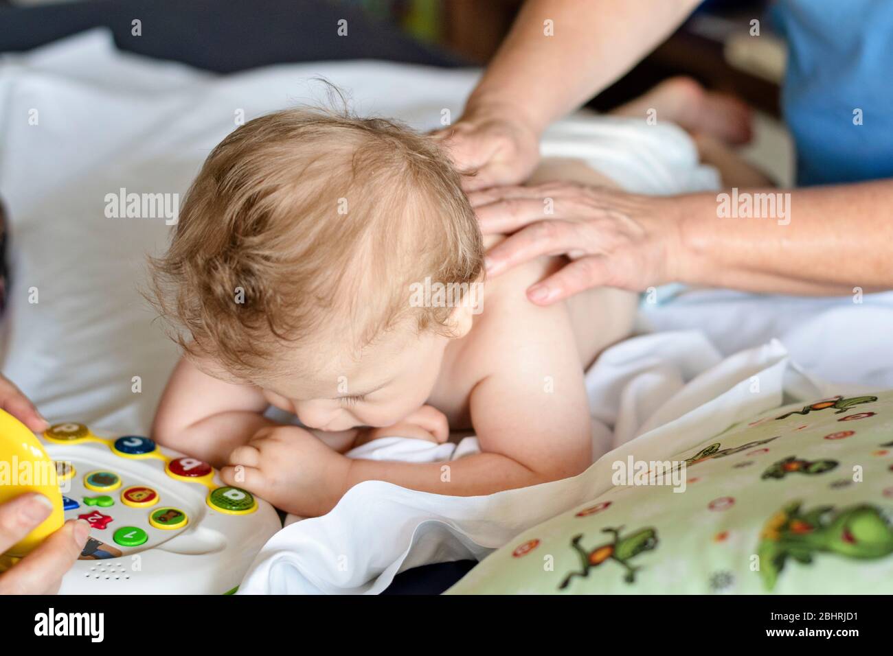 Baby having back massage in a rehabilitation center. Little child on therapy. Massage therapist massaging a baby. Stock Photo
