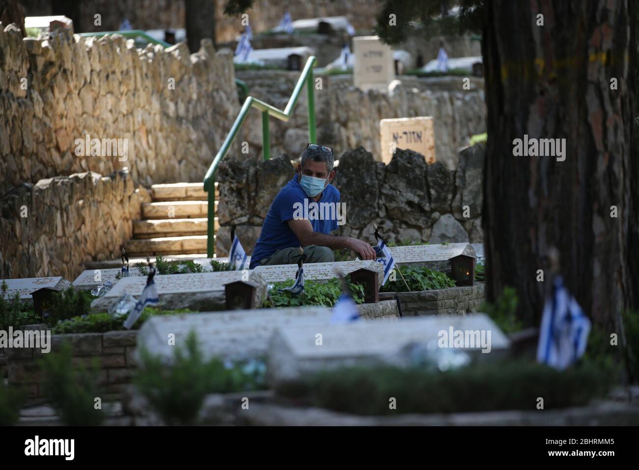 Jerusalem. 27th Apr, 2020. A man wearing protective mask commemorates Israeli fallen soldiers in a military cemetery in Jerusalem on April 27, 2020. Credit: Muammar Awad/Xinhua/Alamy Live News Stock Photo