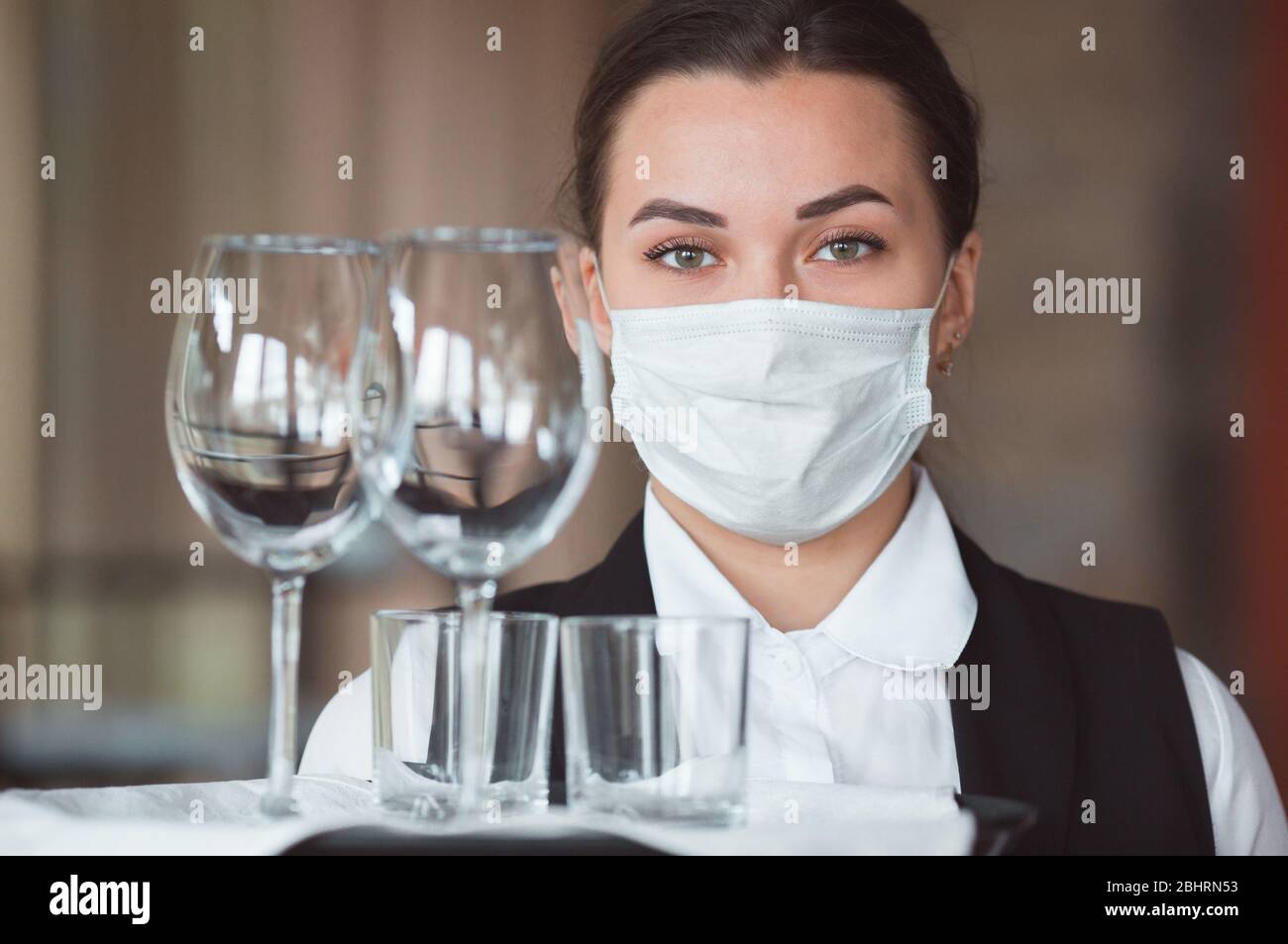 work of a waiter in a restaurant in a medical mask Stock Photo