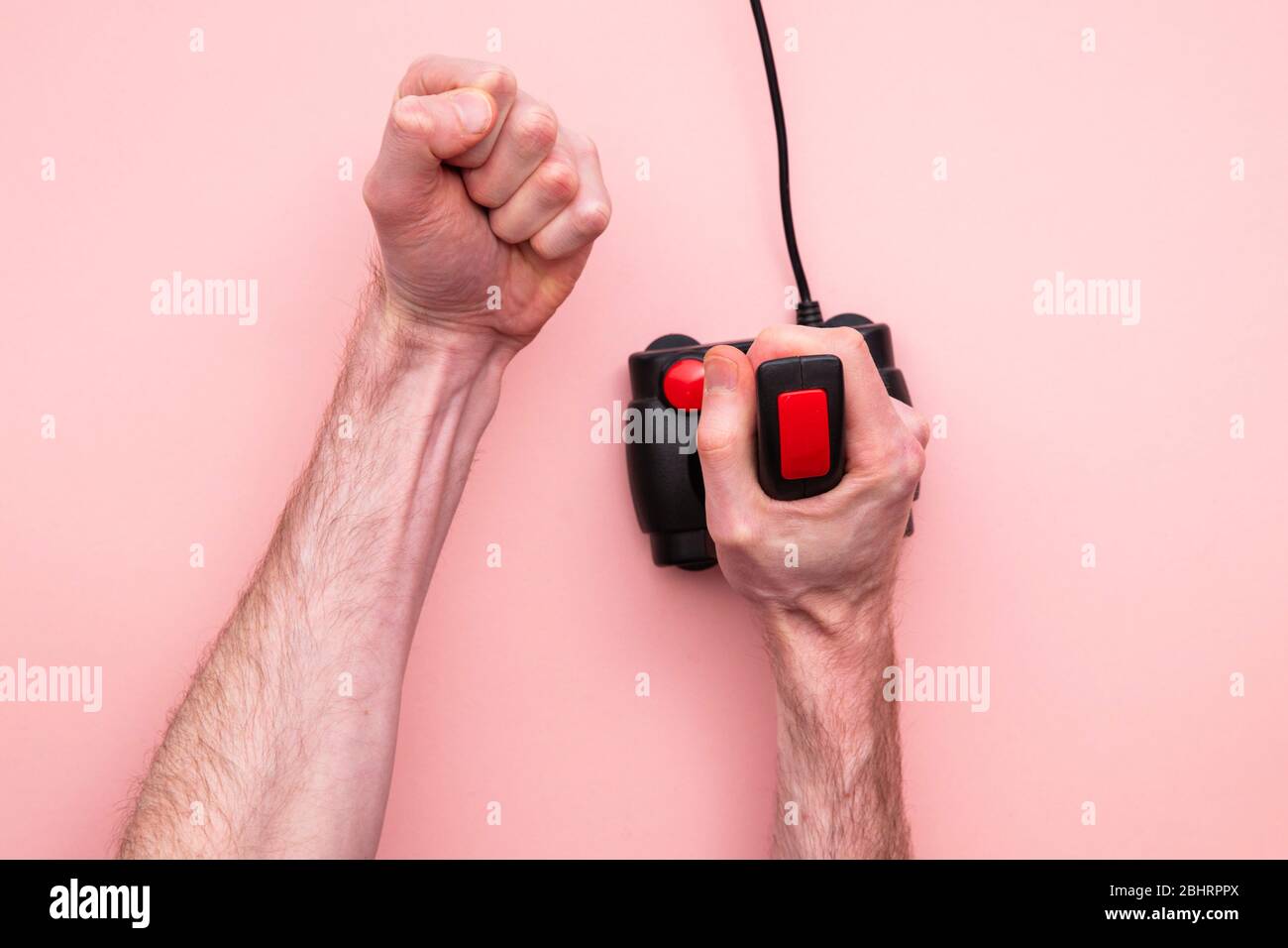 Male hand using retro video game joystick controller. Overhead view Stock Photo