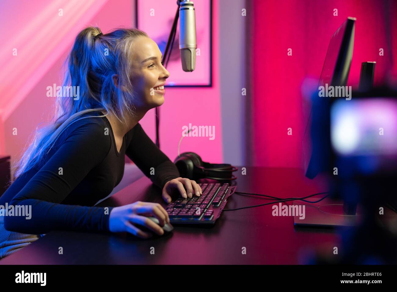 Professional esport gamer girl streaming vlog and plays online video game on PC Stock Photo