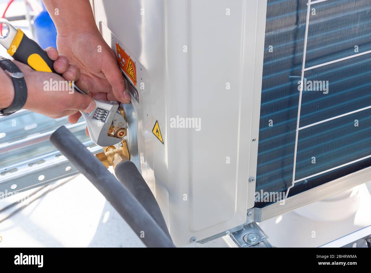 HVAC technician is working on air conditioner units on a roof of new