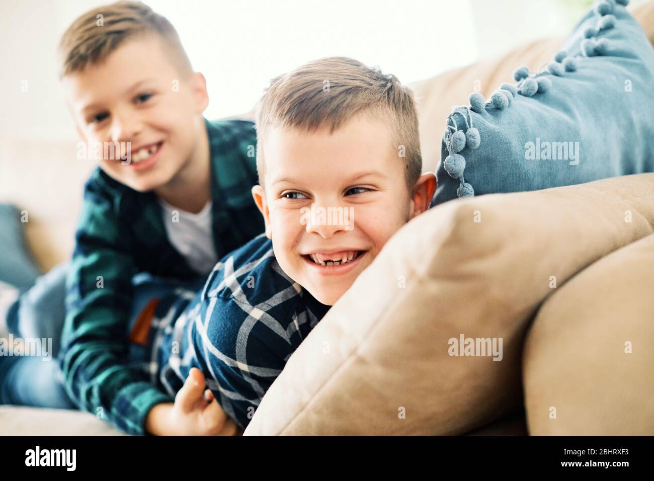 School age brothers laughing and having fun together at home Stock Photo