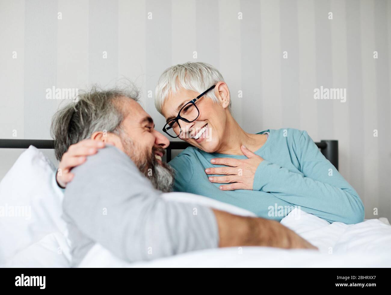 Old couple embracing in bed hi-res stock photography and images - Alamy
