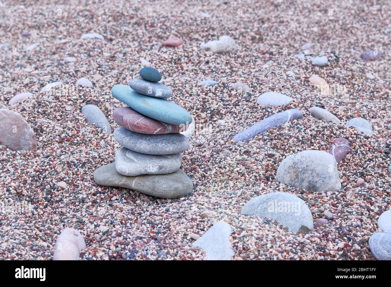 Balanced stones on sea beach. Sand on beach. Pyramid of pebbles. Harmony, balance and relax concept. Stock Photo