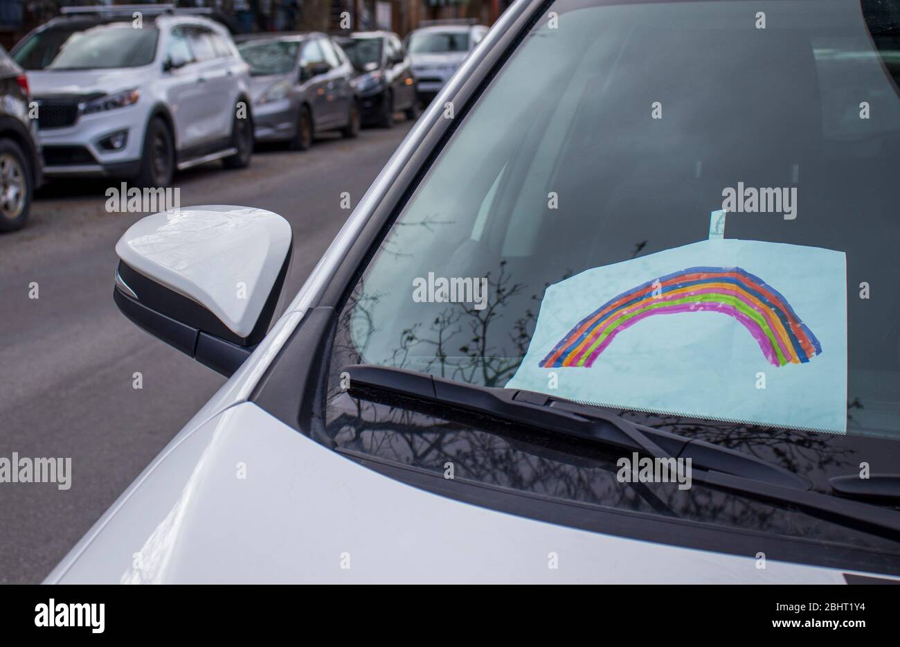 April 16, 2020 - Montreal, Qc, Canada: Rainbow Drawing sticked on a car window dashboard during Coronavirus COVID-19 Pandemic Stock Photo