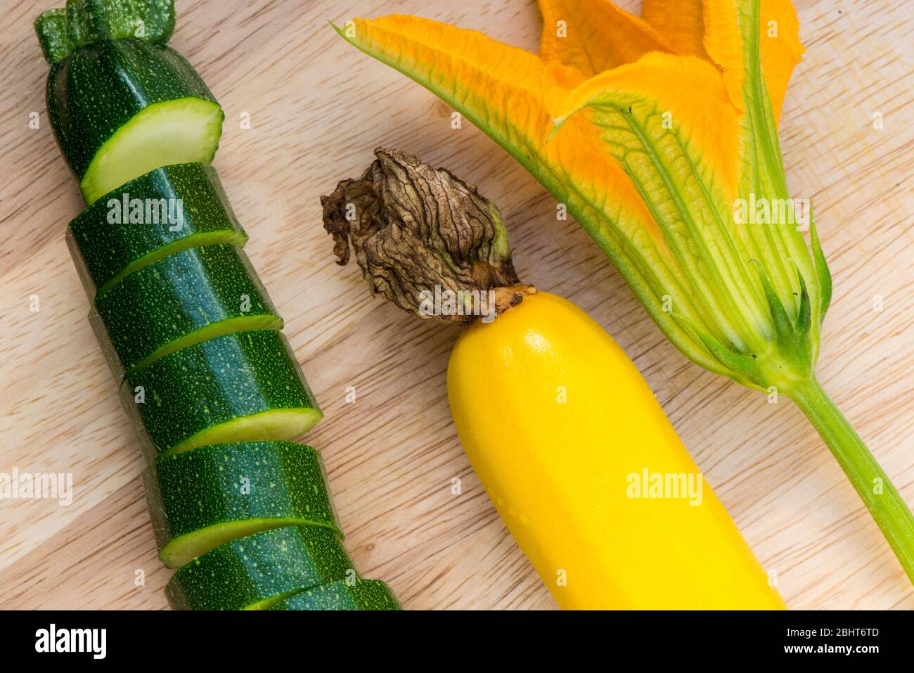 Courgettes with male flower on the kitchen chopping board Stock Photo