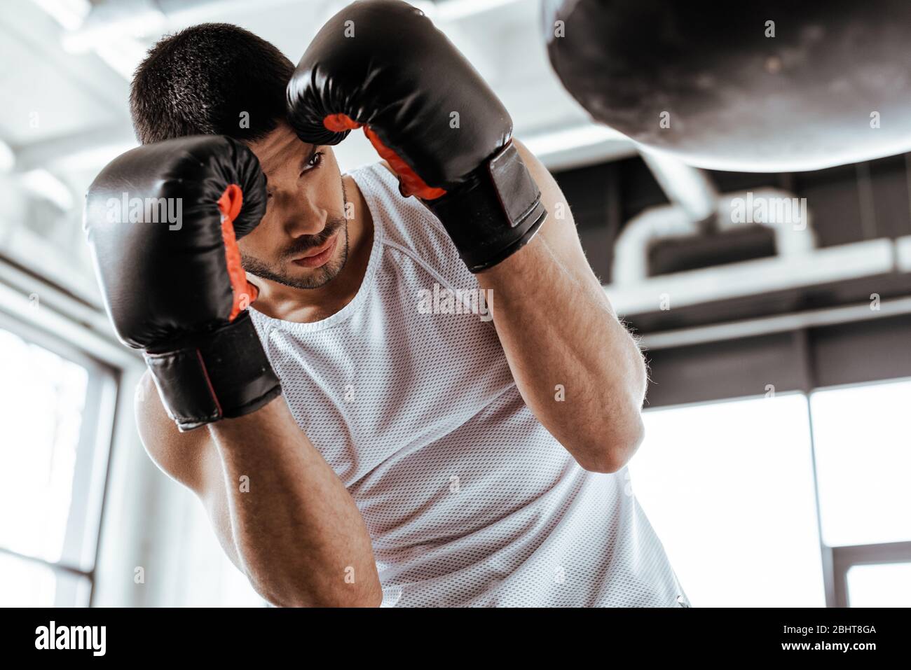 selective focus of sportsman in boxing gloves training with punching