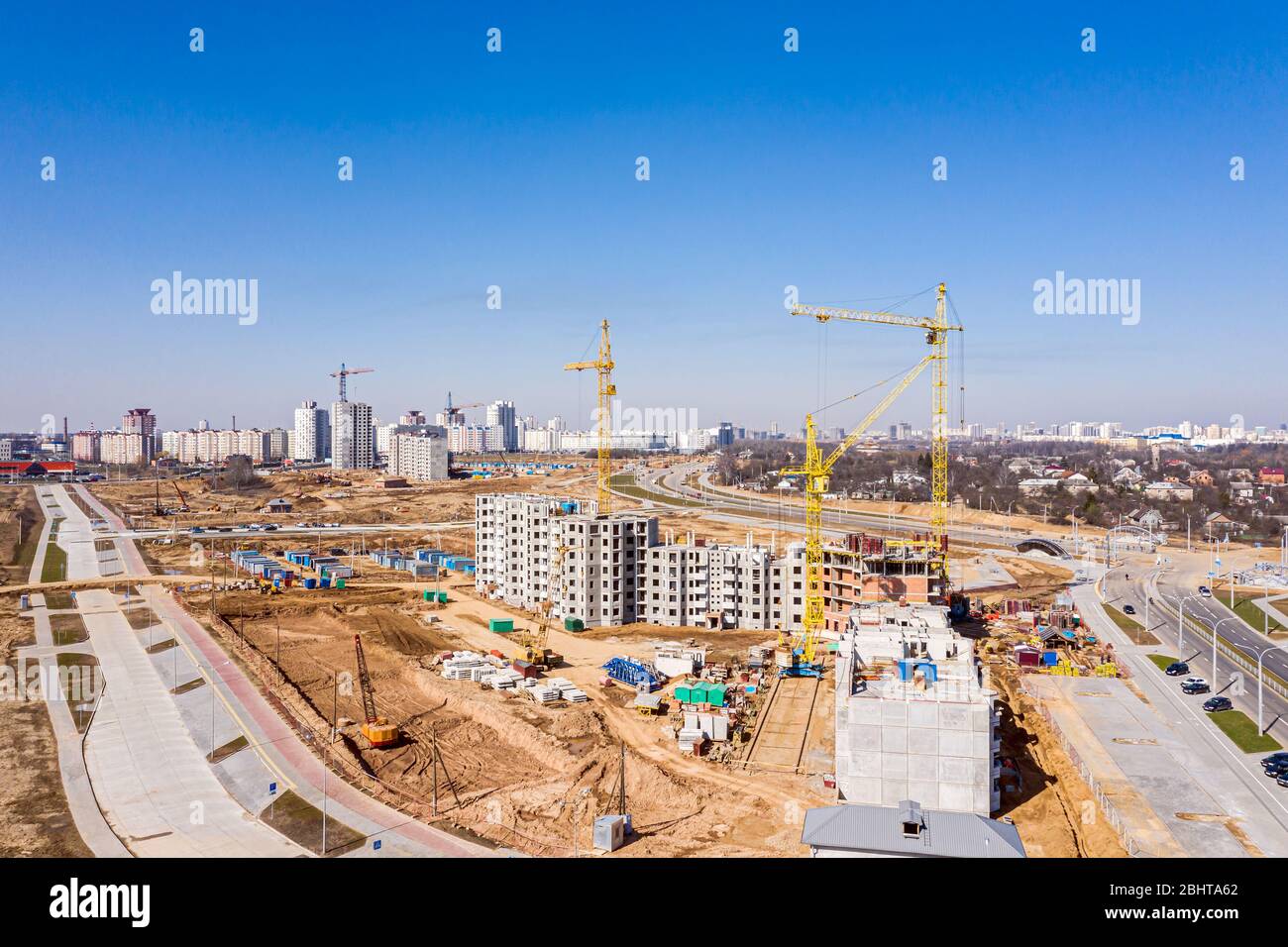 new apartment buildings under construction and tower crane against blue ...