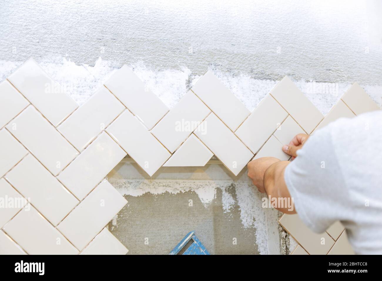 Troweling mortar into the hands of laying the tiles the ceramic tile Stock Photo Alamy