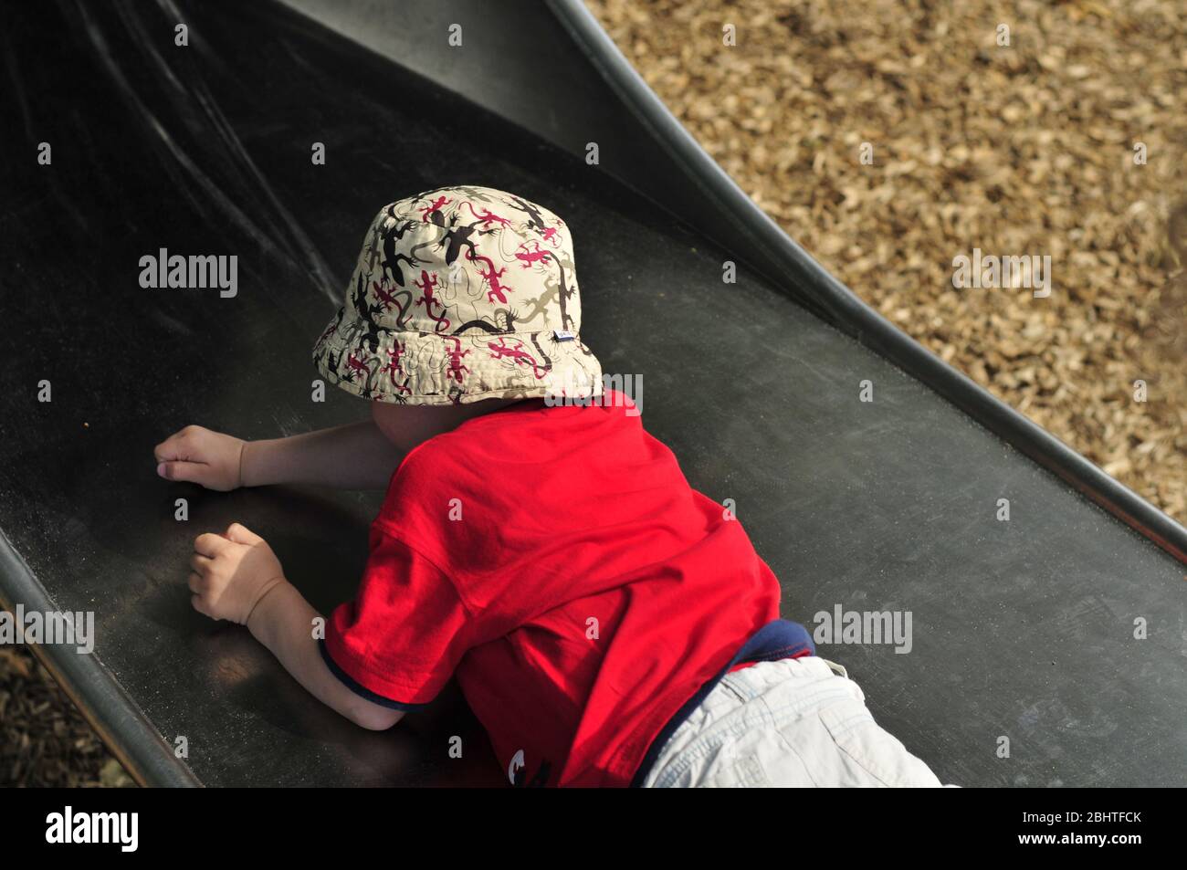 Child backwards on the slide on a playground Stock Photo