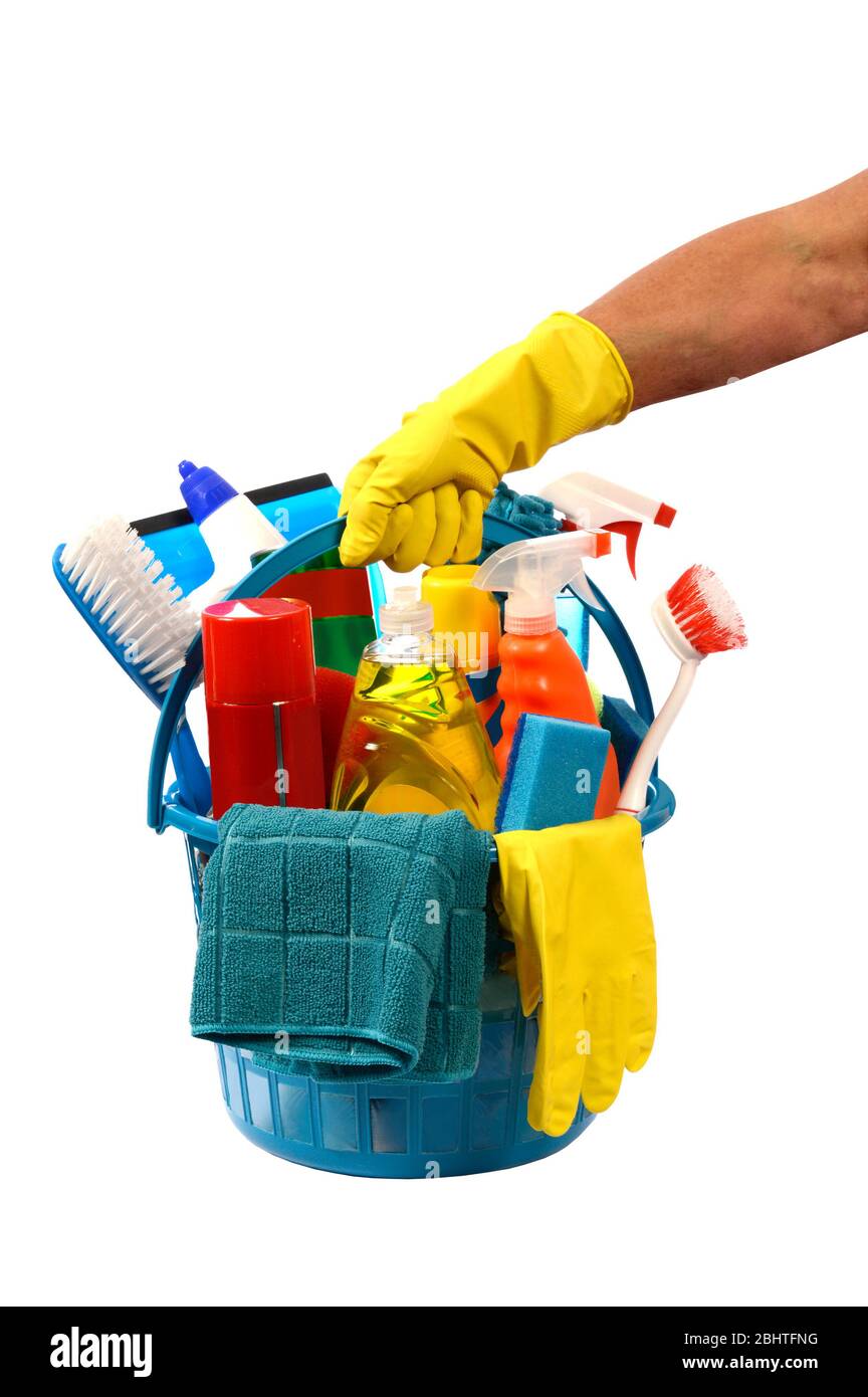 Vertical shot of a yellow gloved hand holding a round blue plastic basket of cleaning supplies isolated on white. Stock Photo