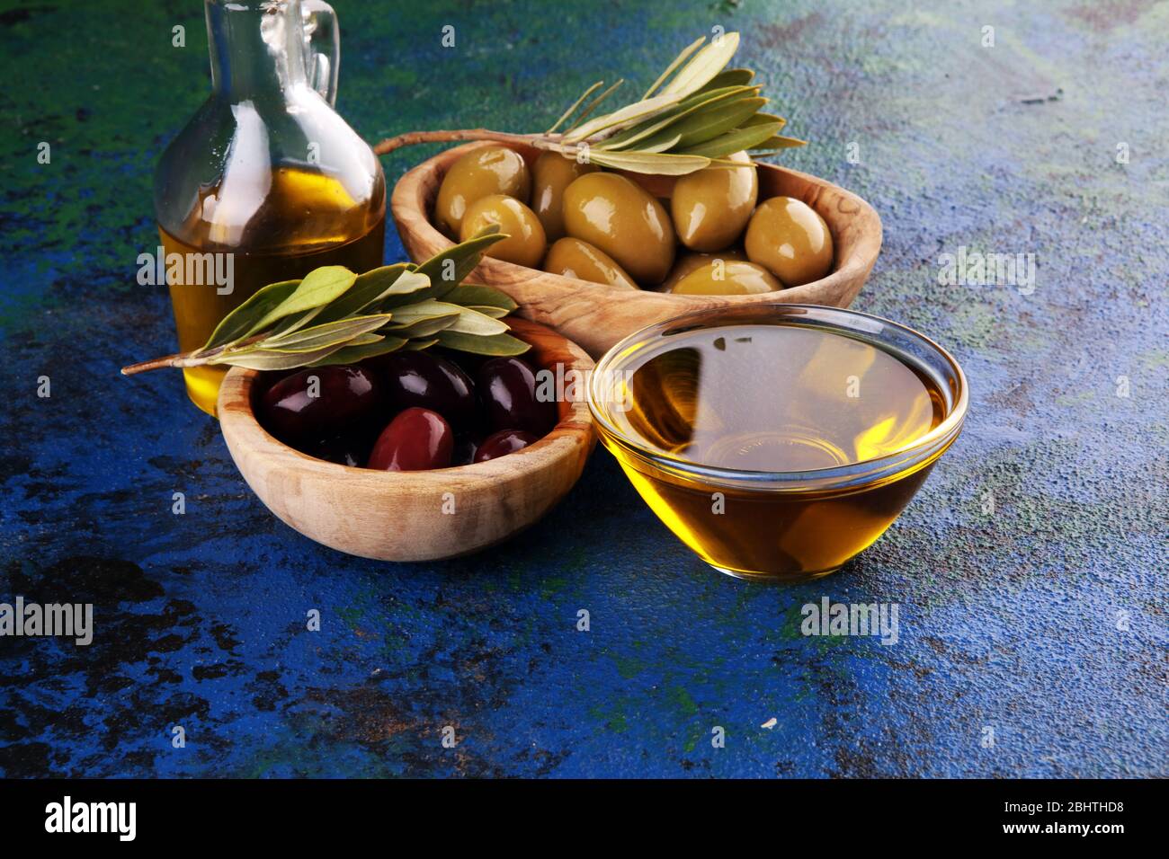 Bottle virgin olive oil and oil in a bowl with some olives Stock Photo ...