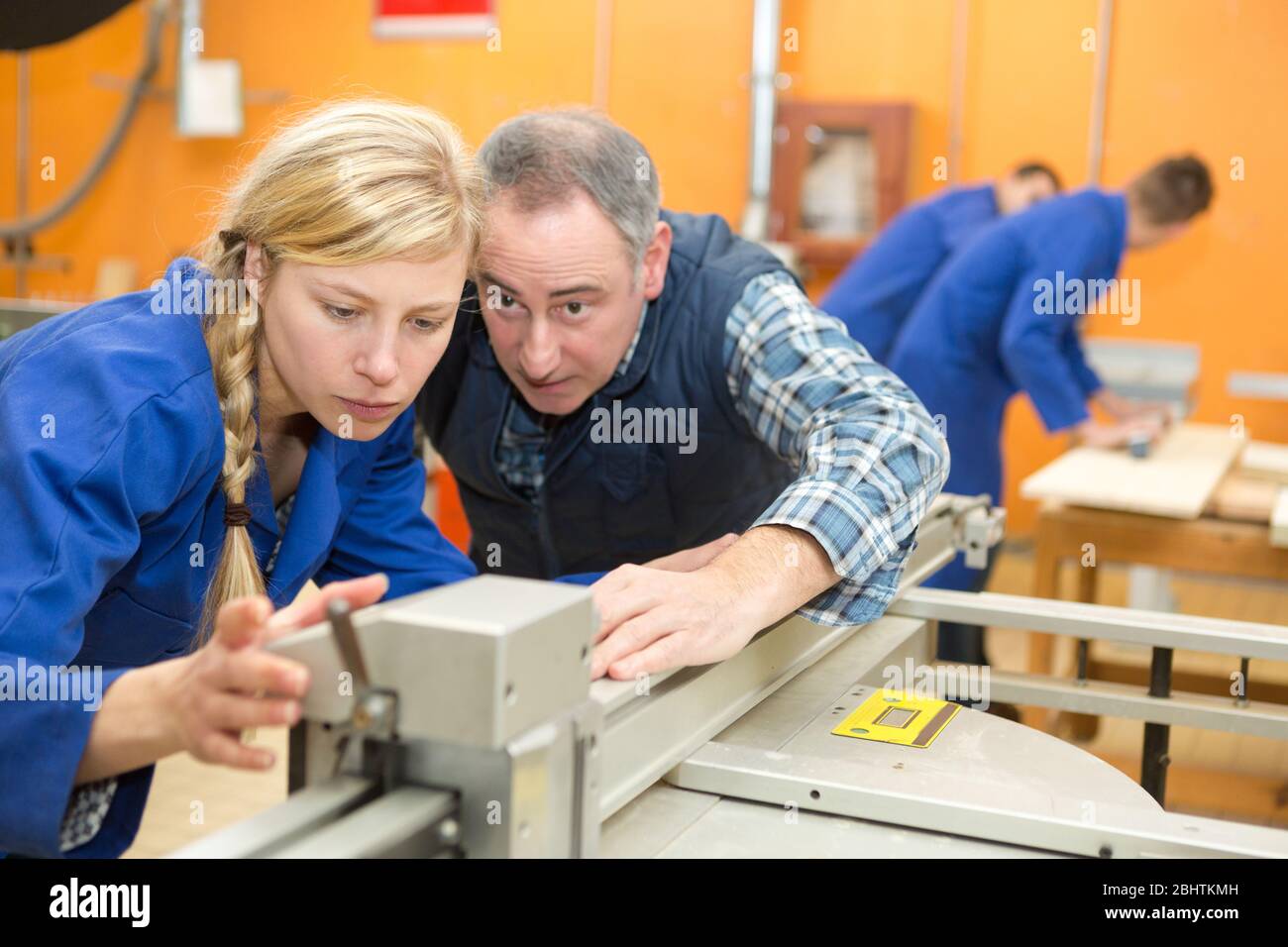 engineer cutting sheet metal with apprentice Stock Photo Alamy