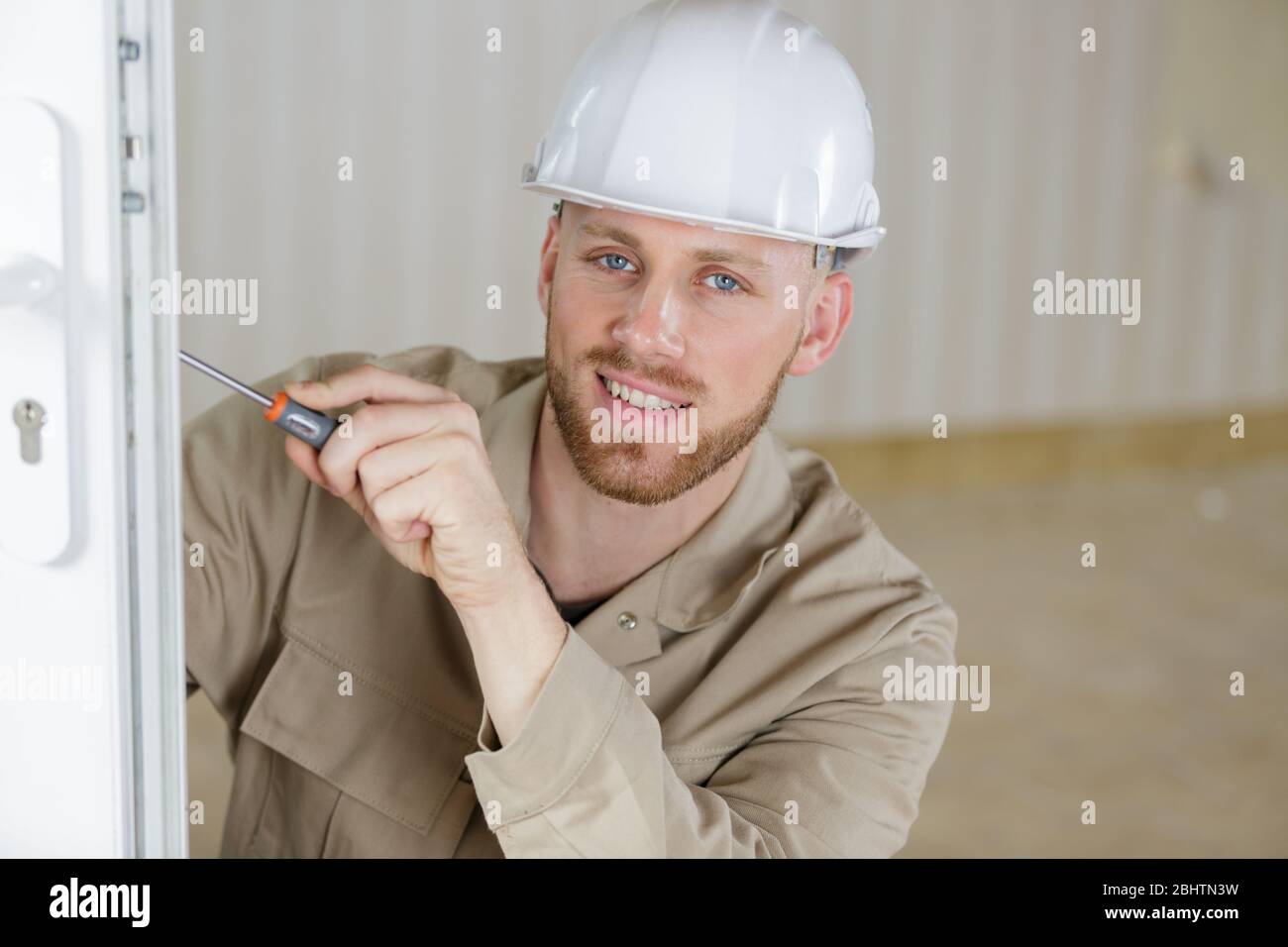young builder repair door lock Stock Photo Alamy