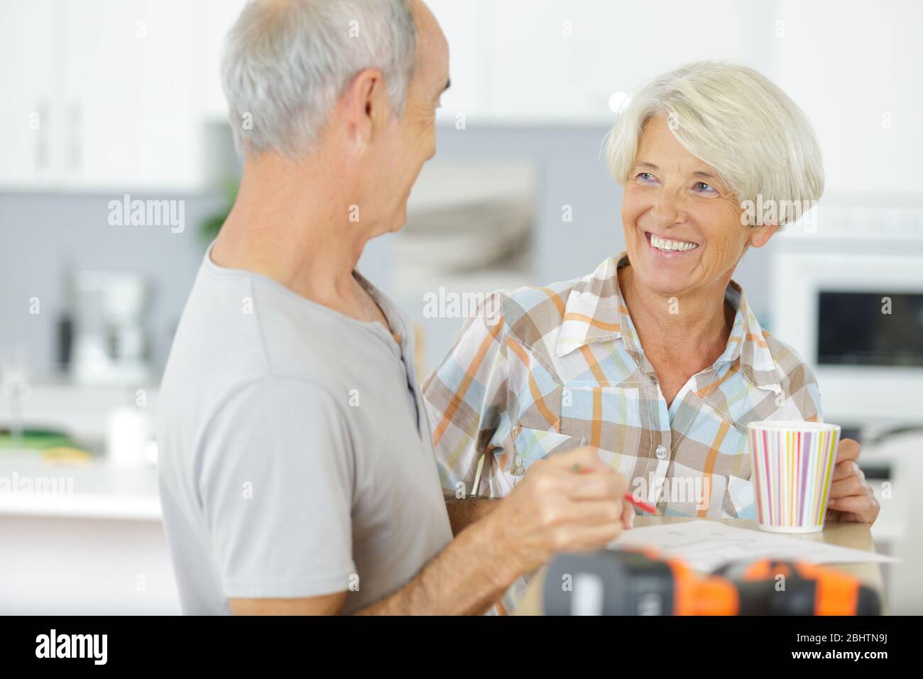 happy older couple having a coffee break while doing diy Stock Photo