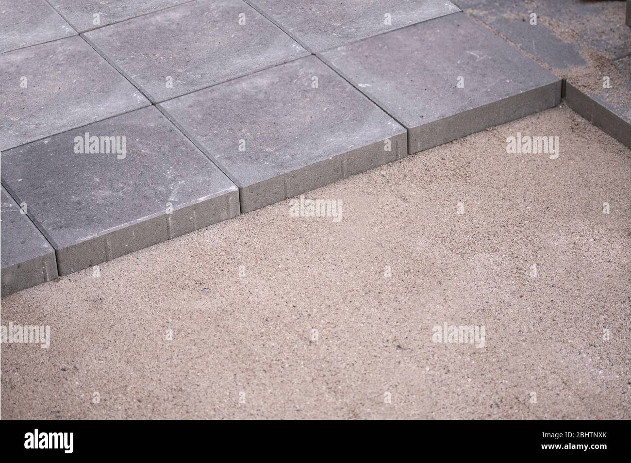 Rows of concrete square pavers or tiles nicely laid in prepared flat