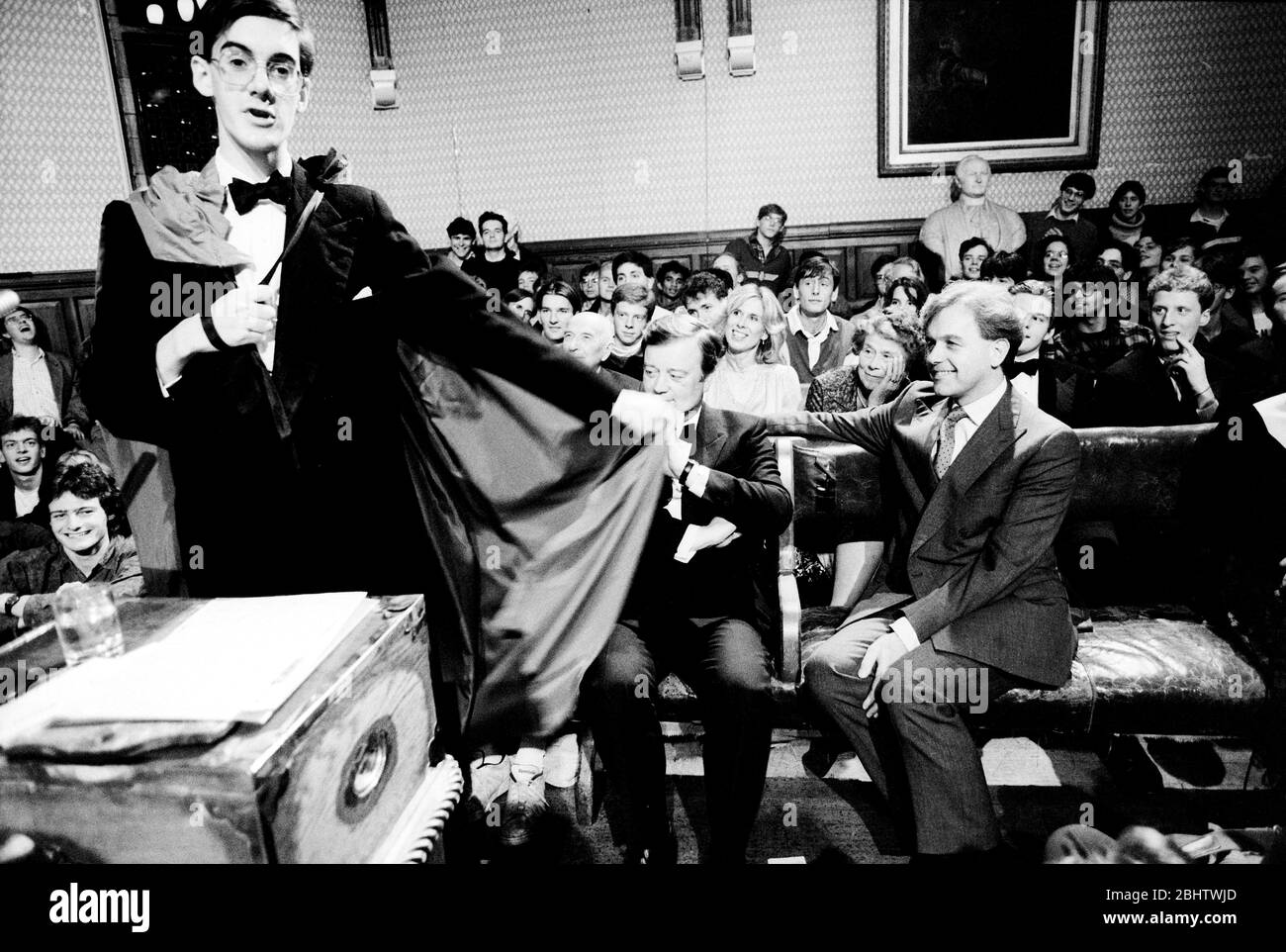 Jacob Rees-Mogg speaks at the Oxford Union Society in 1991. Listening are Kenneth Clarke and John Patten. Stock Photo