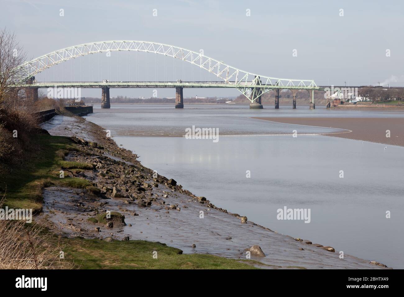 The Mersey Tidal Bore seen from Wigg Island in Runcorn, with the Silver Jubilee Bridge in the background Stock Photo