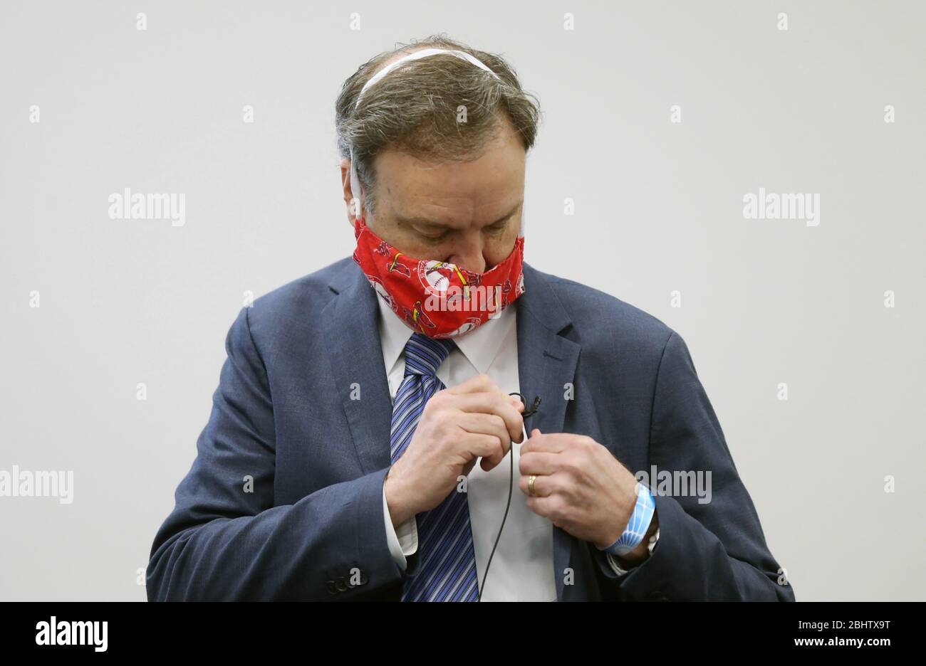 Clayton, United States. 27th Apr, 2020. St. Louis County Supervisor Dr. Sam Page places a microphone on his jacket with face mask in place for his tri-weekly coronavirus press conference, in Clayton, Missouri on April 27, 2020. Photo by Bill Greenblatt/UPI Credit: UPI/Alamy Live News Stock Photo