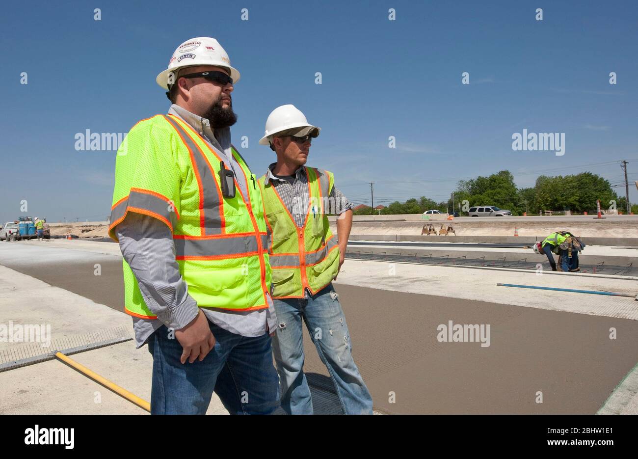 Austin Texas USA, April 6, 2011: Construction supervisor watches over crew working on concrete highway. ©Marjorie Kamys Cotera/Daemmrich Photography Stock Photo