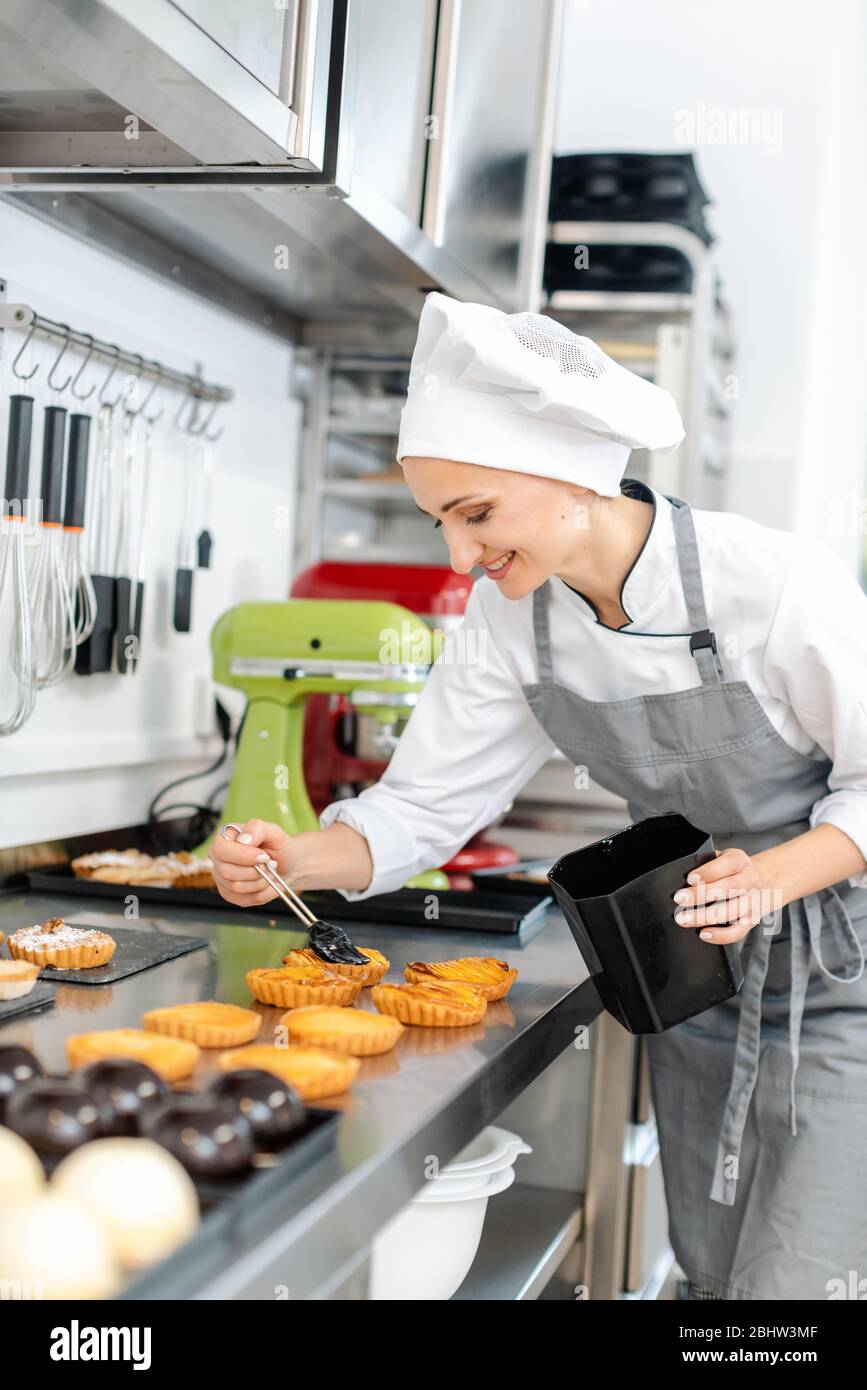 Pastry chef glazing little cakes Stock Photo