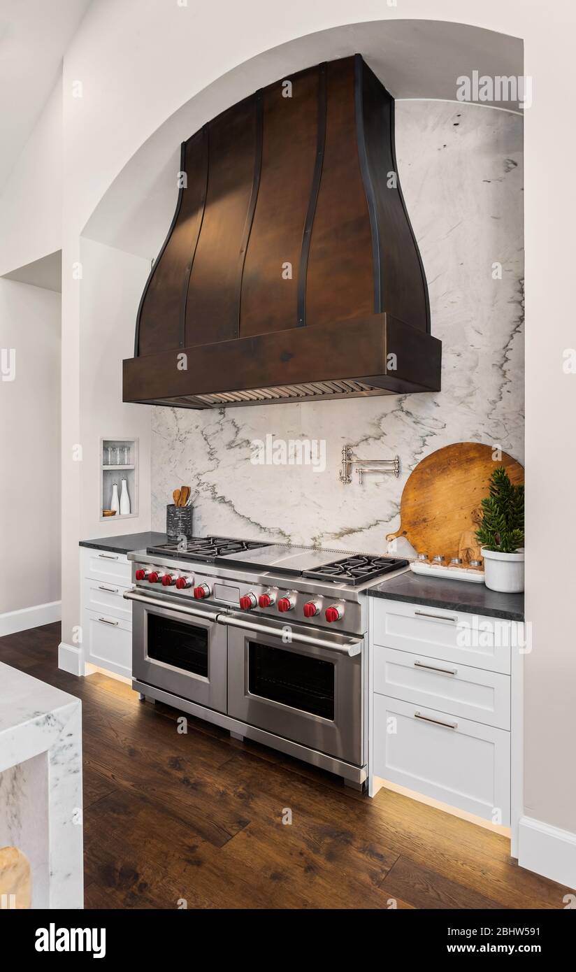 Beautiful stainless steel oven and large range hood in new luxury home Stock Photo