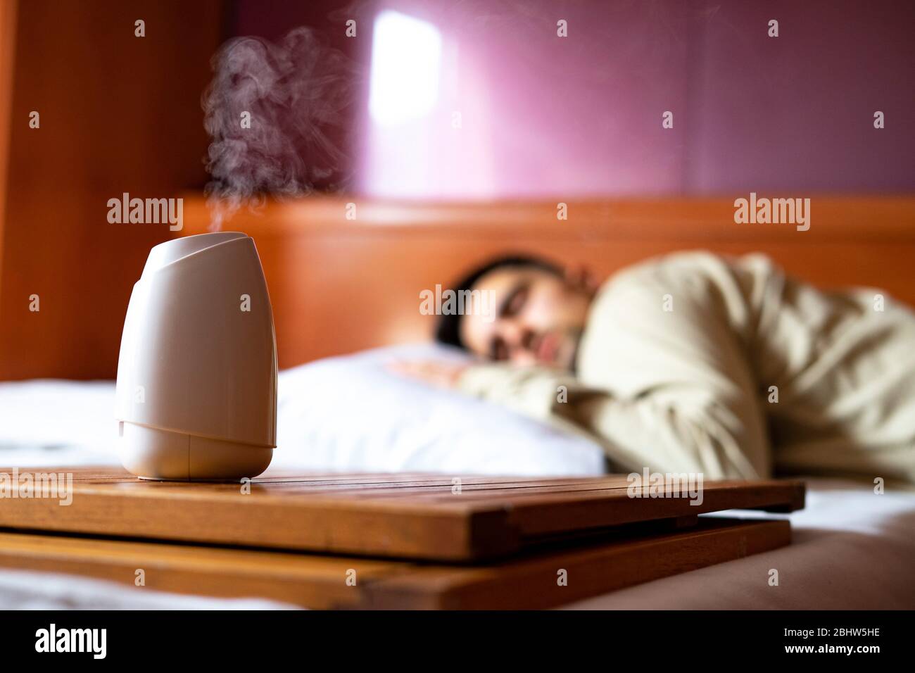 Air freshener taking out perfume in the bedroom with a sleeping man