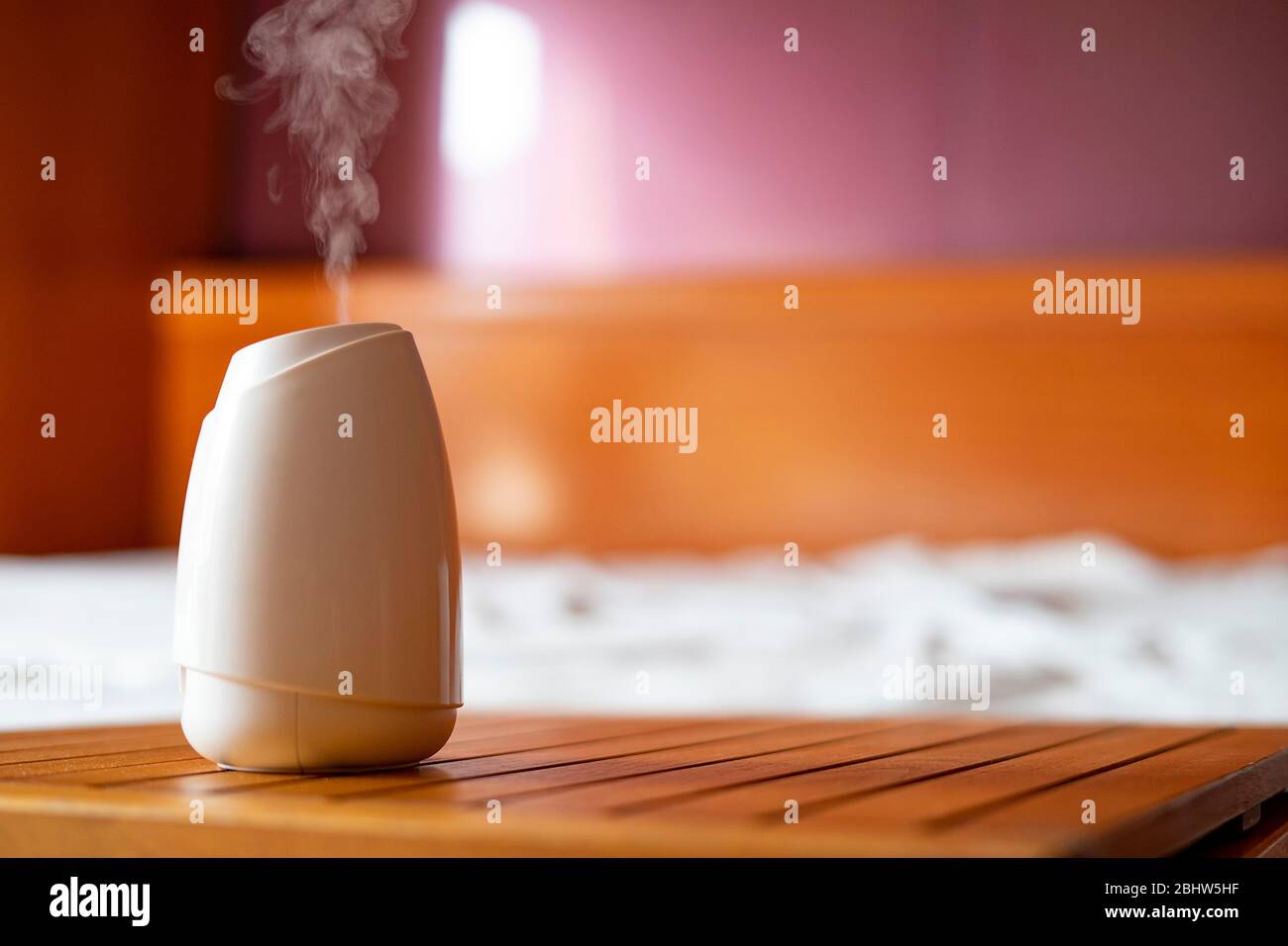 White air freshener taking out perfume in the bedroom. Air freshener