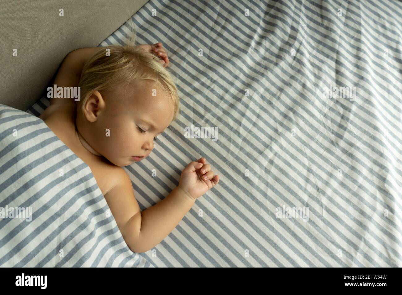 Cute baby sleeps well, raising hands up Stock Photo Alamy
