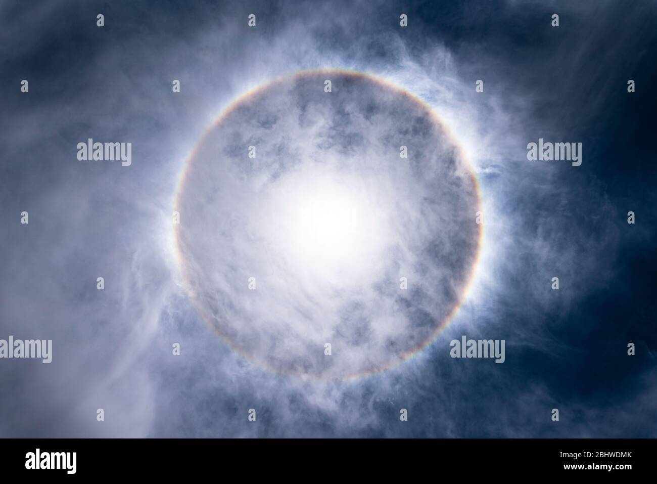 The Sun, with an amazing halo around the sun created by light refraction because of ice crystals on the upper atmosphere layers in the troposphere Stock Photo