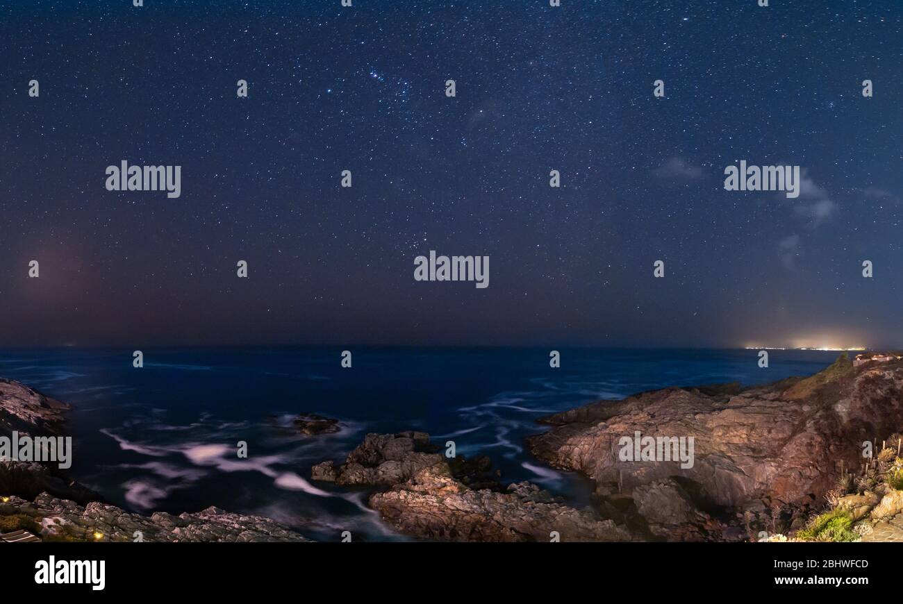 Amazing nightscape with the Pacific Ocean and the stars of the night sky  above with a blue sky from twilight. We can see the waves and water  splashing Stock Photo - Alamy, image size:1300x870