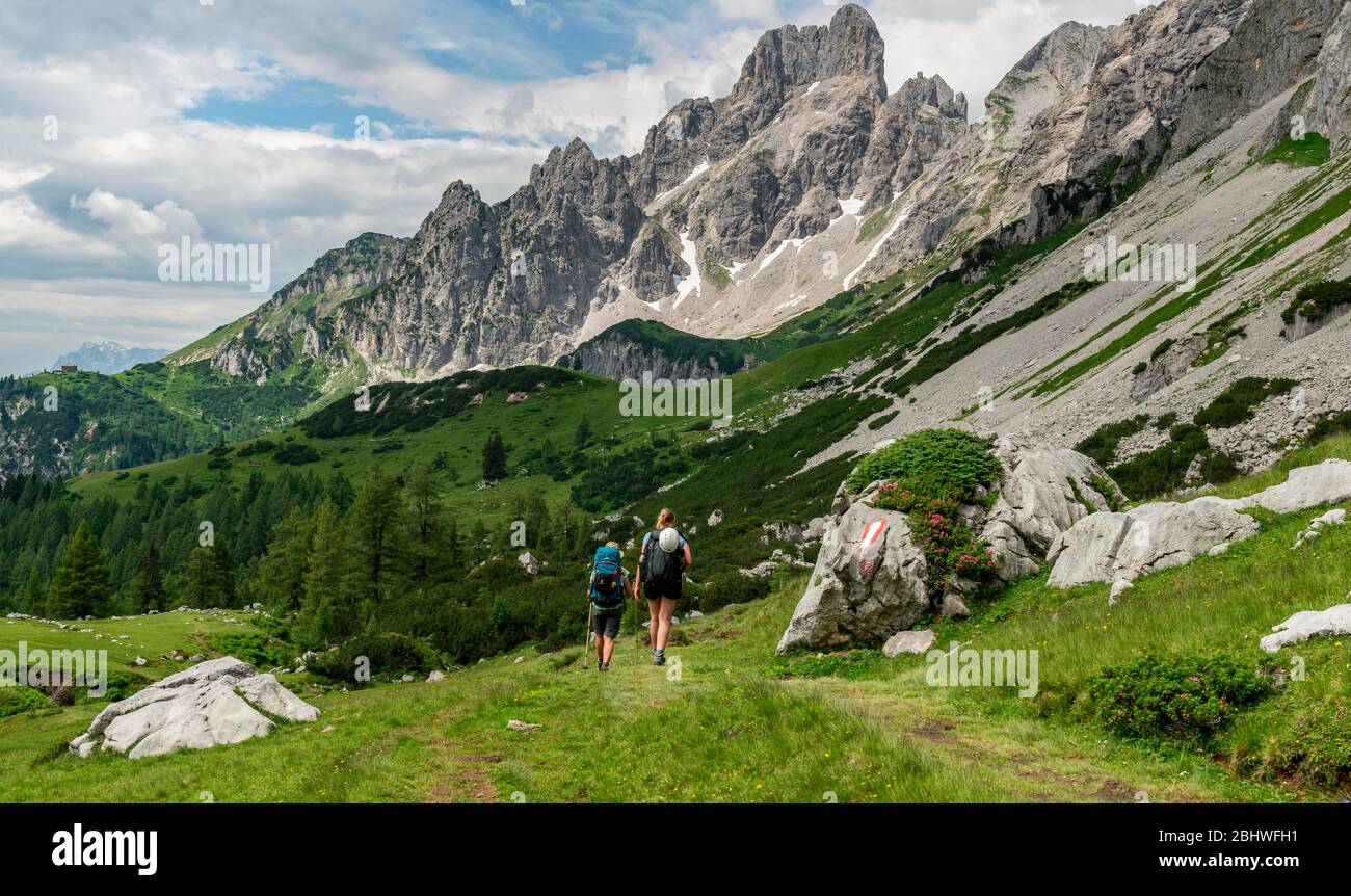 Two hikers on a marked hiking trail from the Adamekhuette to the Hofpuerglhuette, mountain ridge with mountain peak Grosse Bischofsmuetze Stock Photo