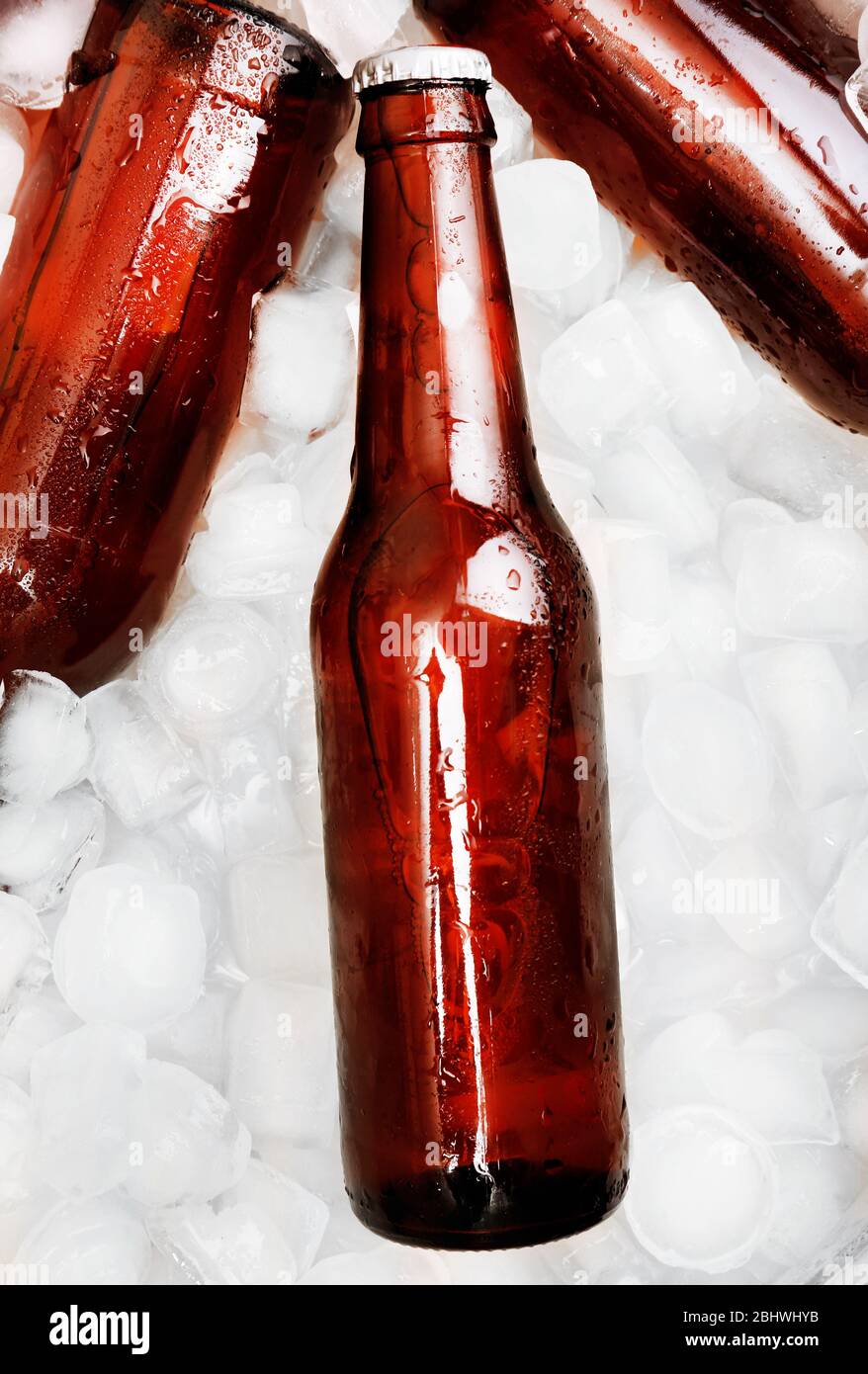 Glass bottles of beer with ice cubes, closeup Stock Photo Alamy