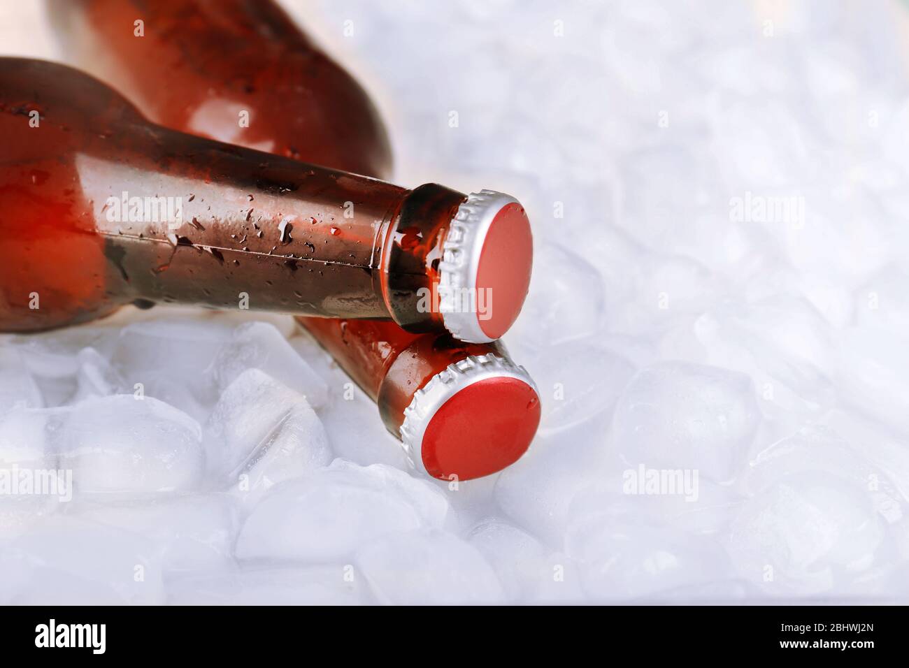 Glass bottles of beer with ice cubes, closeup Stock Photo Alamy