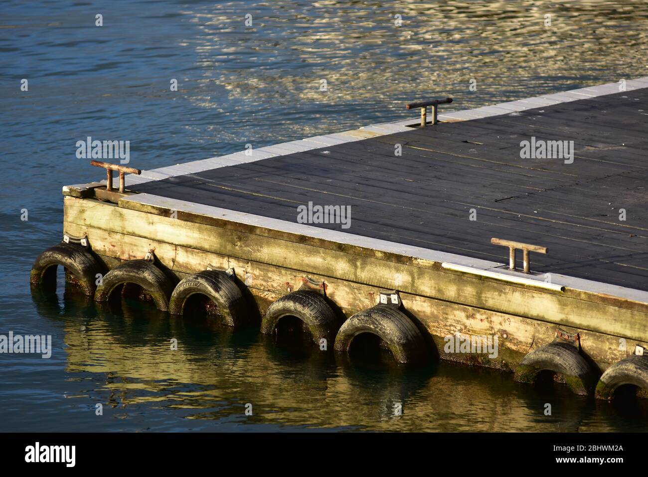 Floating jetty with wooden floor and metal welded cleats and car tyre fenders Stock Photo Alamy