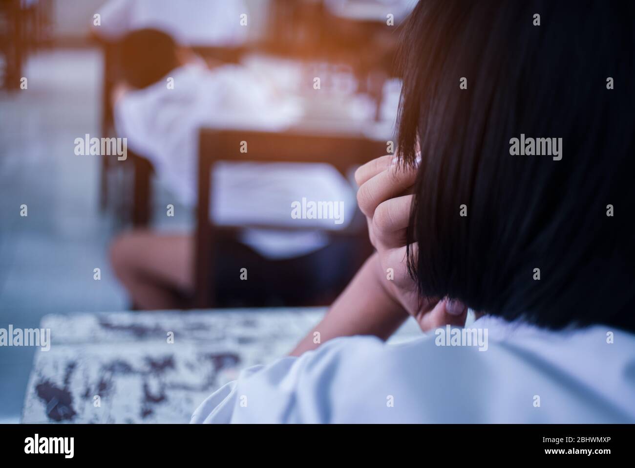 School students thinking and taking exam answer in classroom with stress Stock Photo