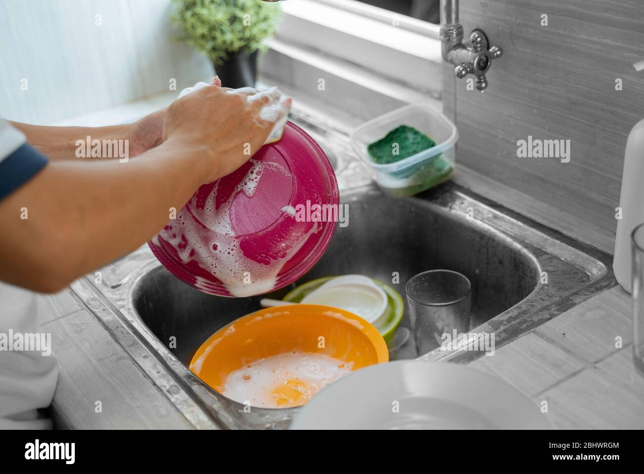 Cropped image of a hand is washing dishes while doing cleaning at home Stock Photo Alamy