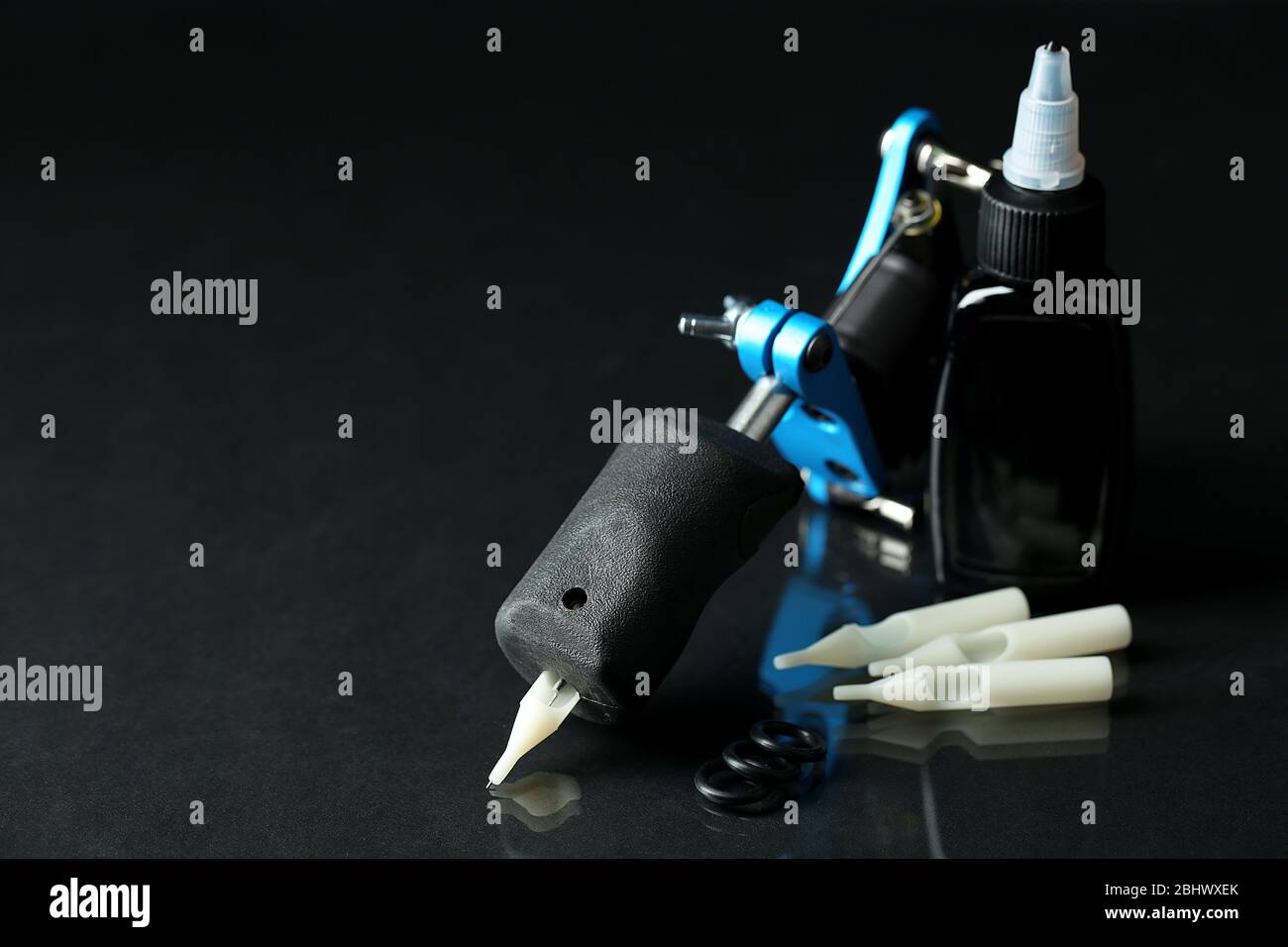 Tattoo machine and tattoo Supplies, on dark background Stock Photo - Alamy