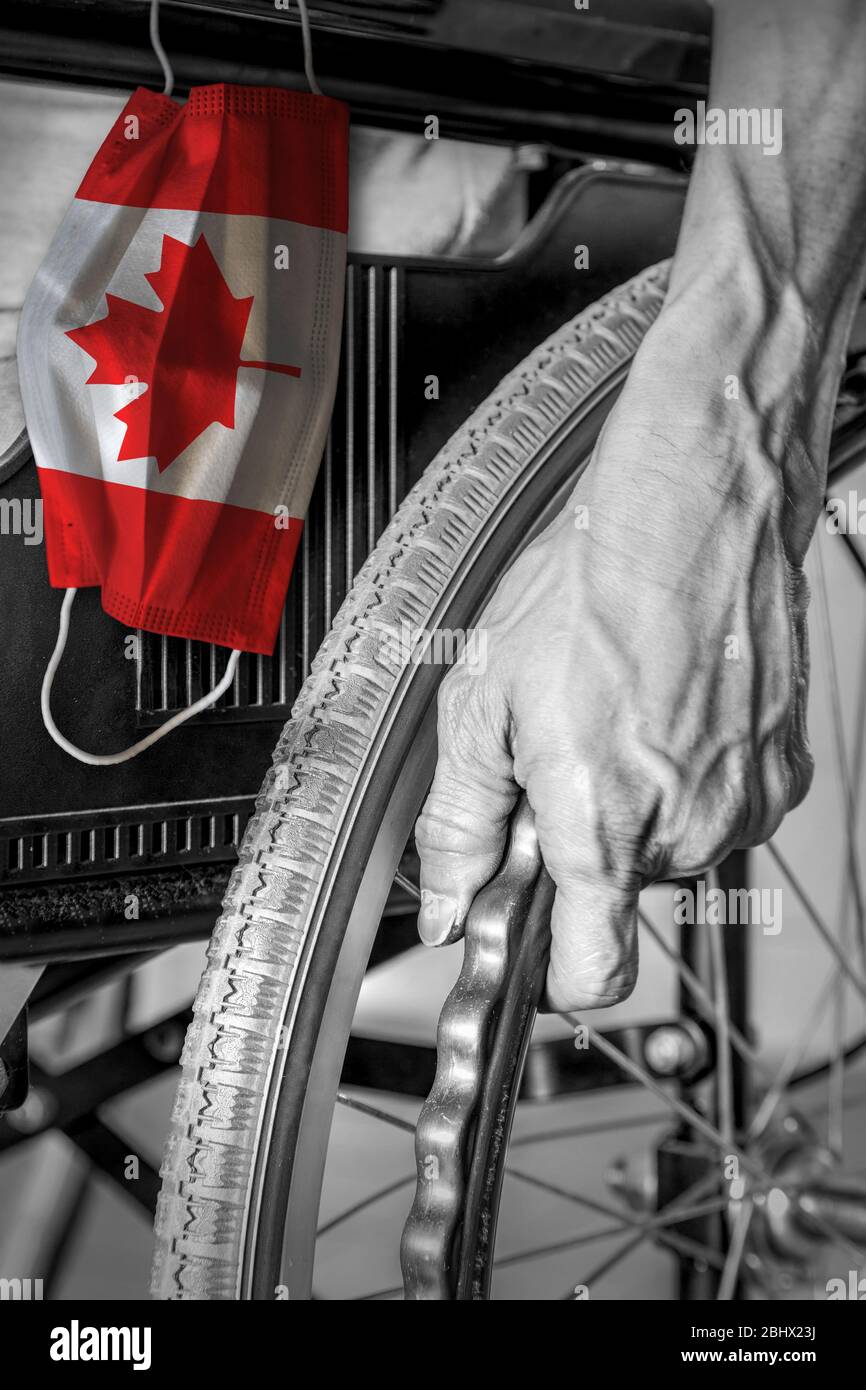 Senior in wheelchair at nursing home in black and white with hanging Canadian flag face mask in color. Concept of Covid-19 coronavirus outbreak in Can Stock Photo