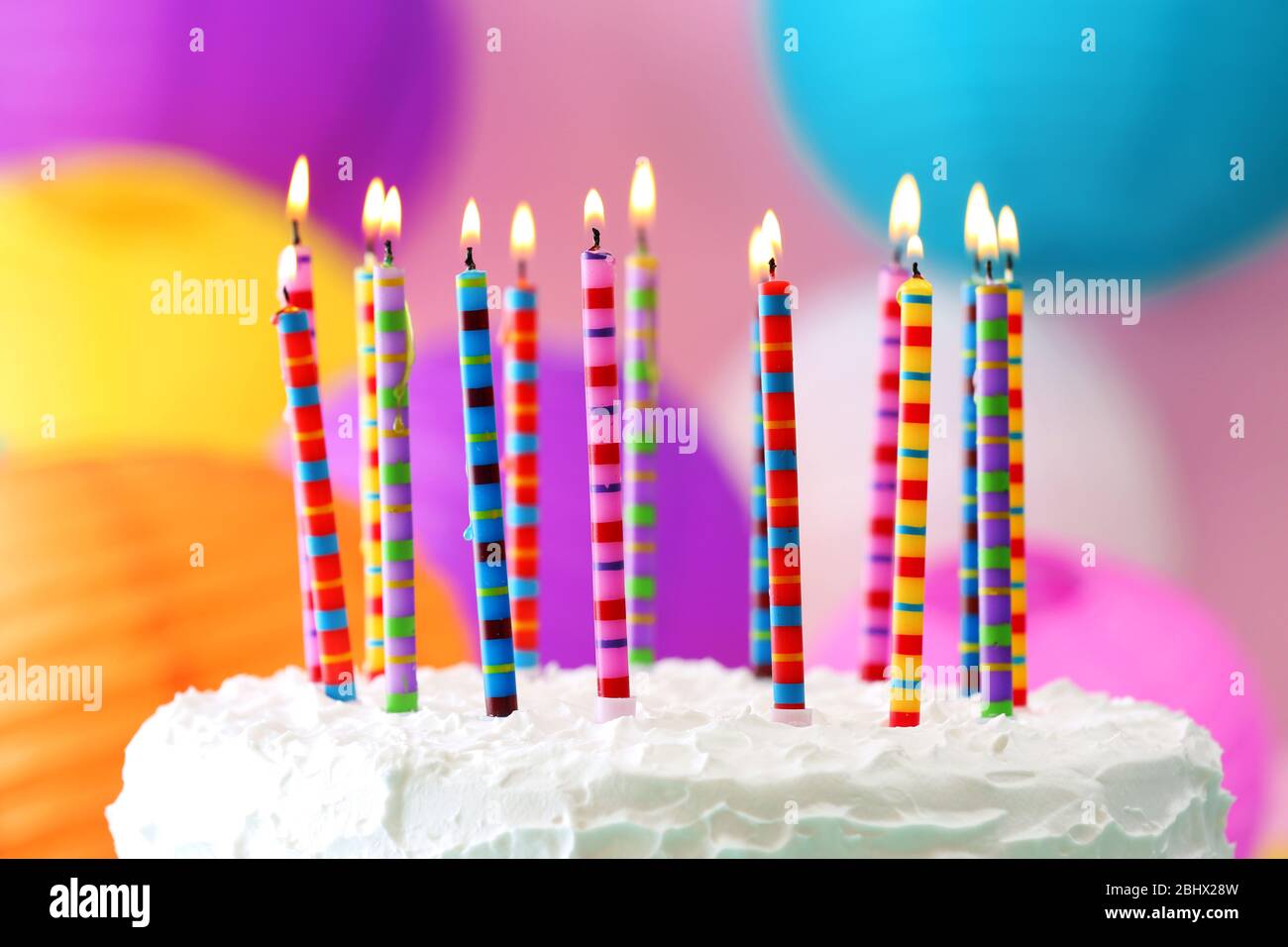 Birthday cake with candles on colorful background Stock Photo - Alamy