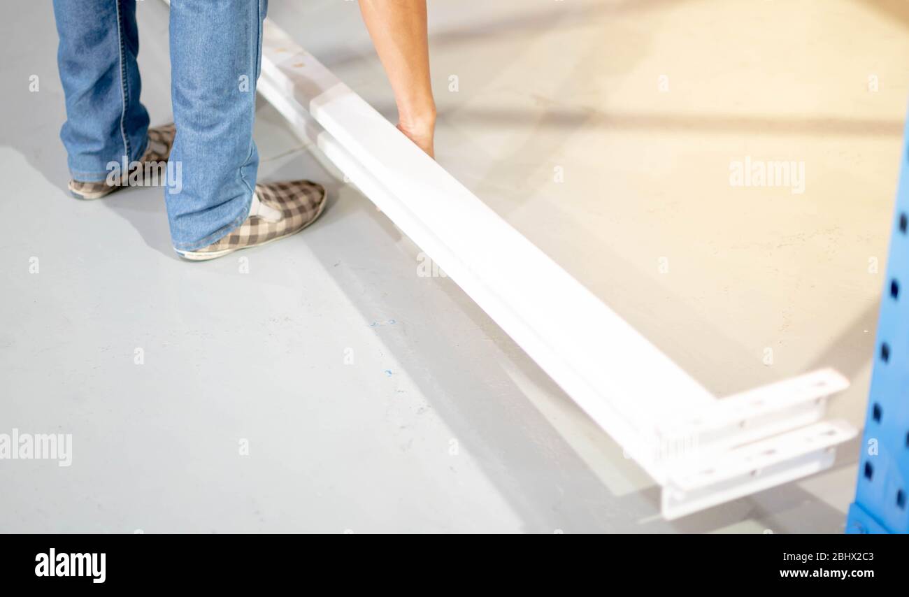Male hand preparing to assembling the metal rack in in warehouse or ...