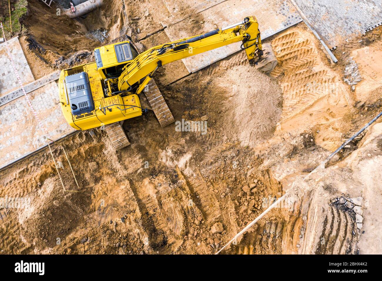 yellow excavator working on a construction site. aerial view from flying  drone Stock Photo - Alamy