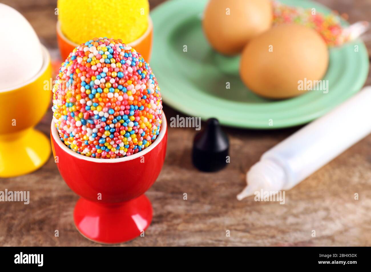 Decoration Easter eggs with colorful beads on wooden table, closeup Stock Photo