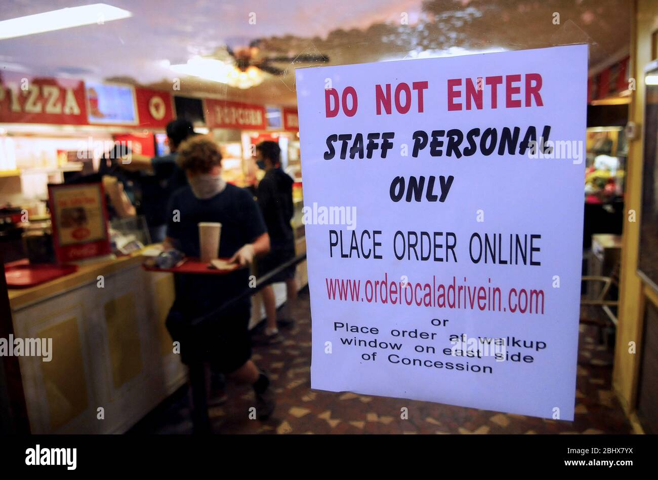 Ocala, United States. 27th Apr, 2020. A sign hangs at the concession stand advises customers to place their order online at the Ocala Drive-in Theatre, one of the few Florida movie theaters permitted to operate during the COVID-19 stay-at-home order.Half of the parking spaces are roped off, providing 10-12 feet of social distance between each vehicle, and food orders are delivered to cars by servers wearing protective masks and gloves. Credit: SOPA Images Limited/Alamy Live News Stock Photo