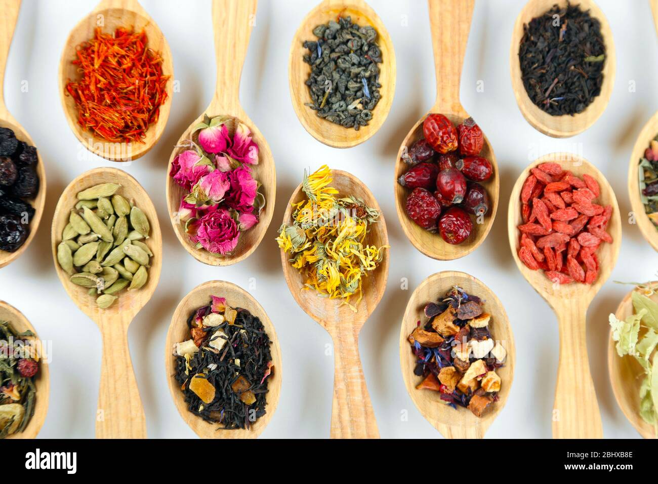Collection of tea and natural additives in wooden spoons, isolated on ...