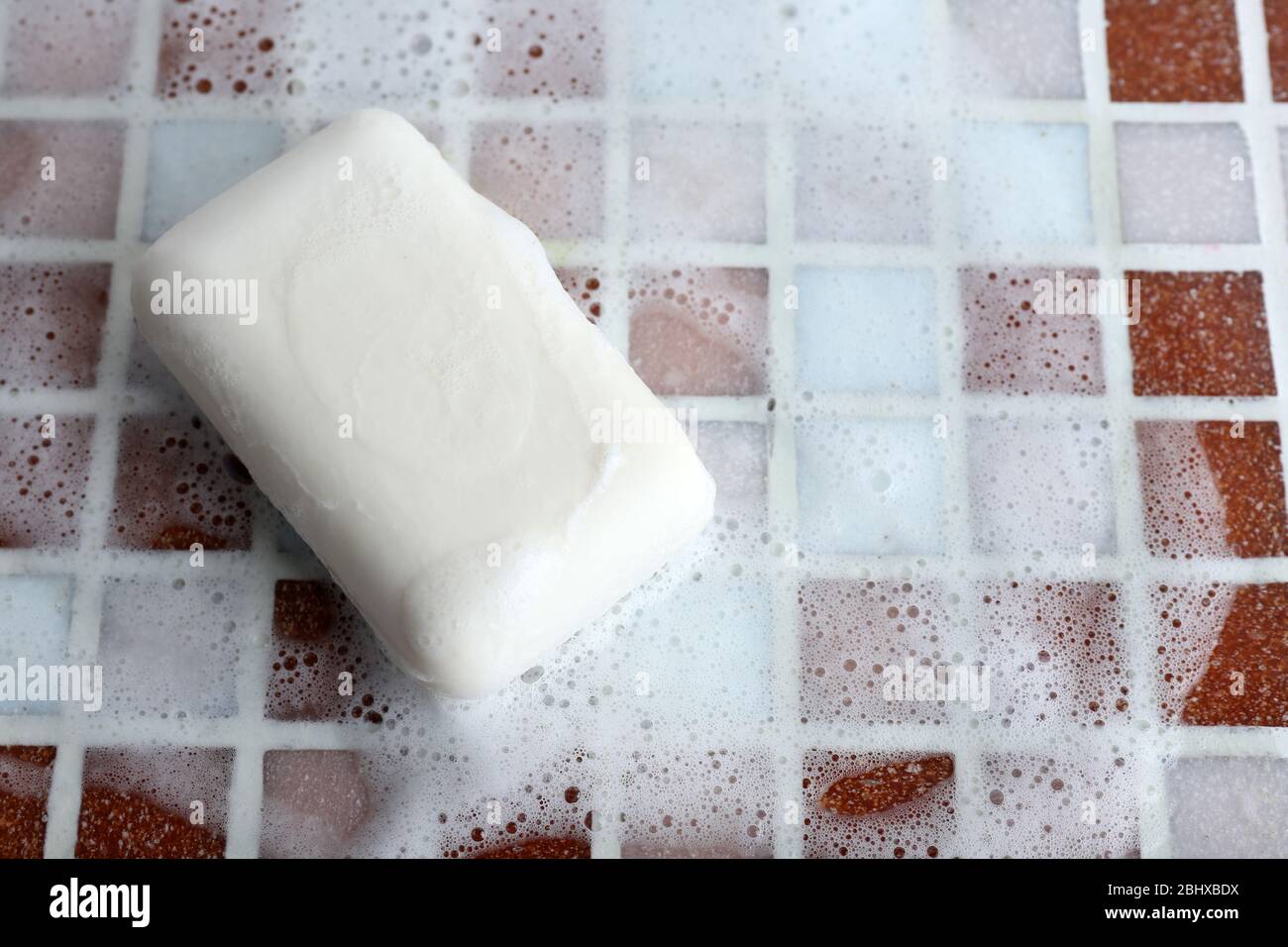 Soap with bubble on mosaic tiles background Stock Photo - Alamy