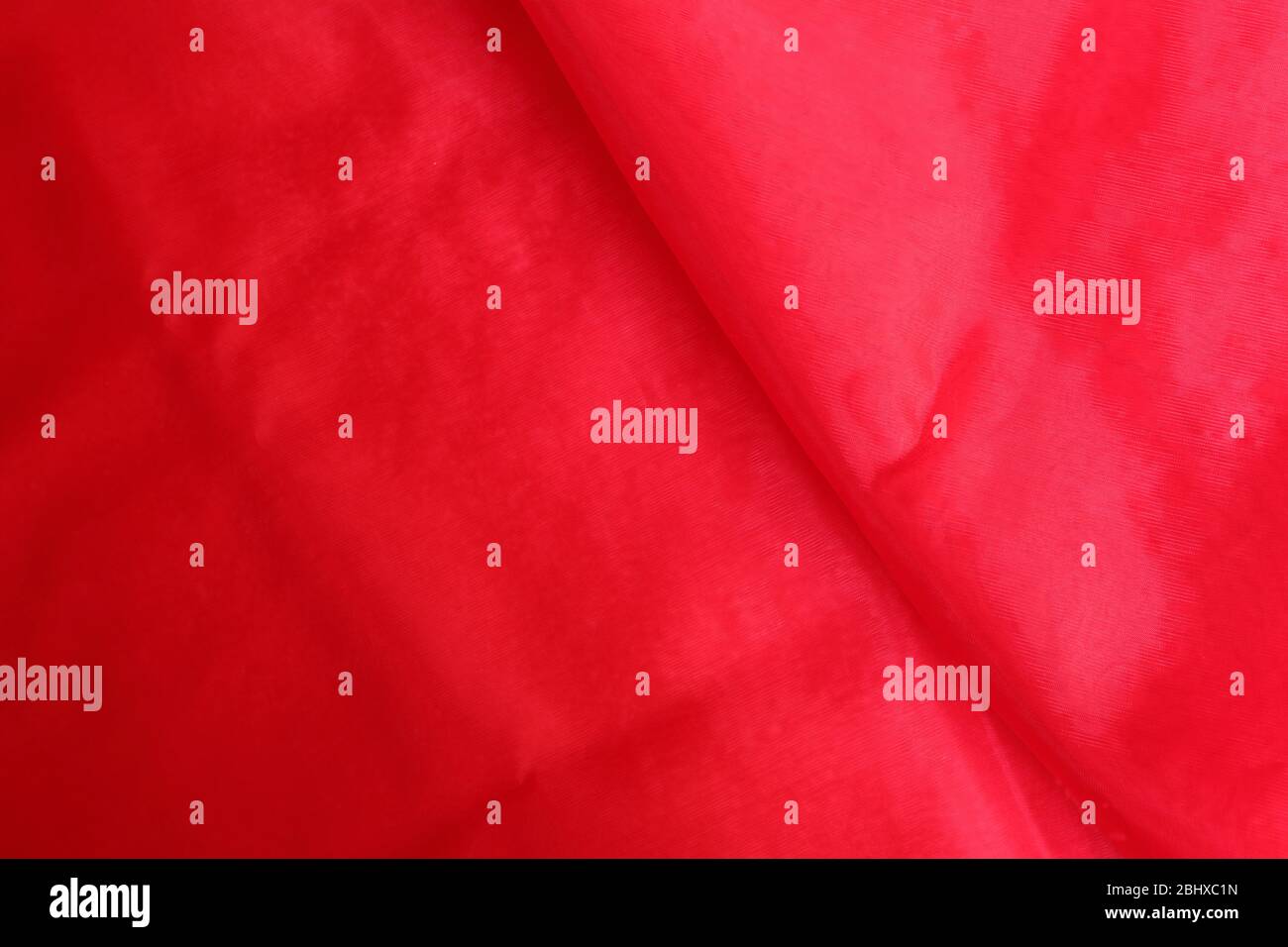 Vibrant red charmeuse fabric with wrinkles and creases suitable for background, celebration concept Stock Photo