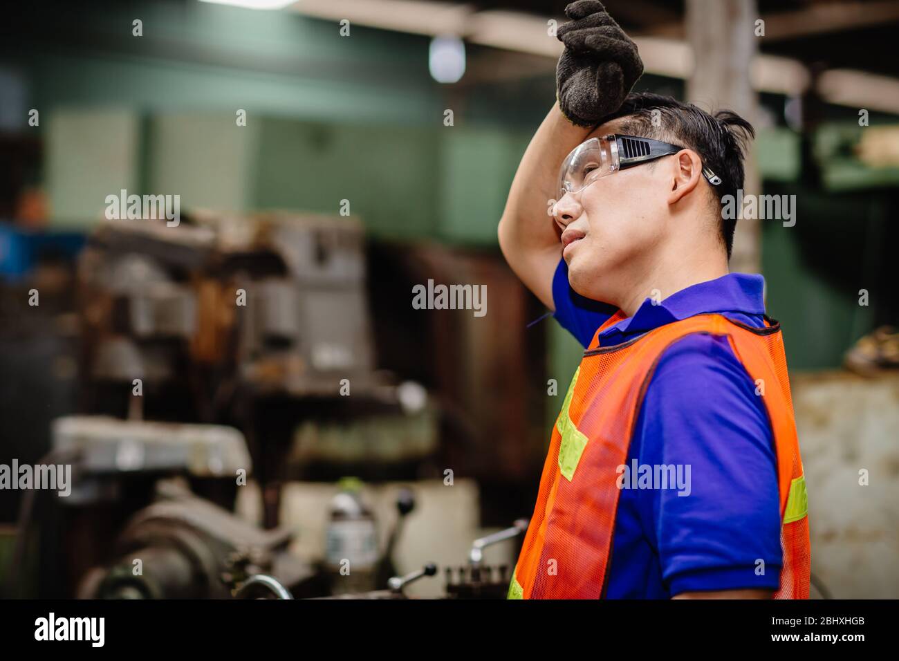 Tired worker, headache hot weather over heat unhealthy engineer working in heavy industry factory. Stock Photo