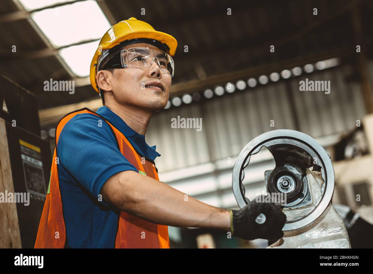 Asian Woker proud in heavy industry working in production line process with happy smiling in factory. Stock Photo
